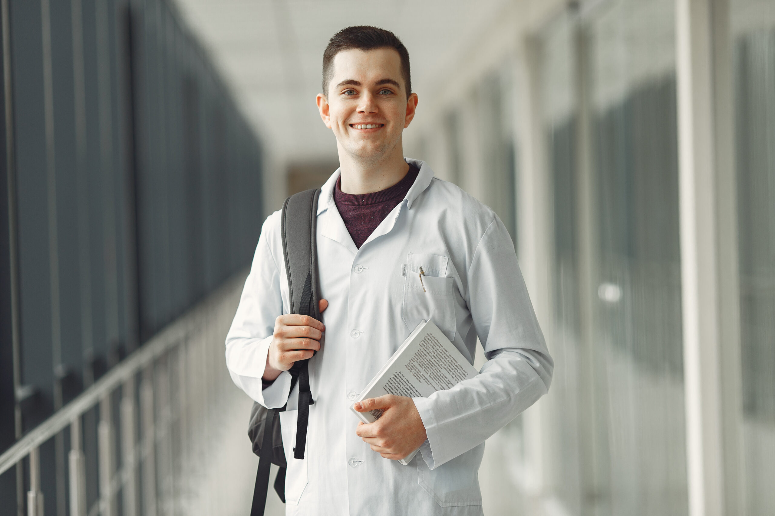 Medical student in with a backpack is standing in a modern clini